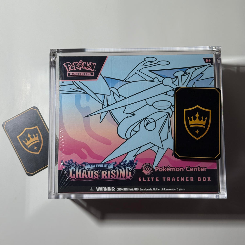 Pokémon Center Chaos Rising Elite Trainer Box in its clear plastic packaging, displayed on a white surface next to a Kings Protection business card
